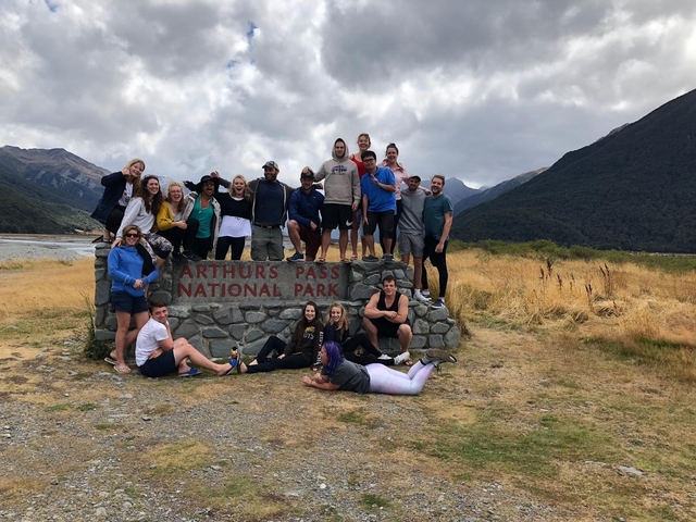 Large group of people posing on a national park sign.