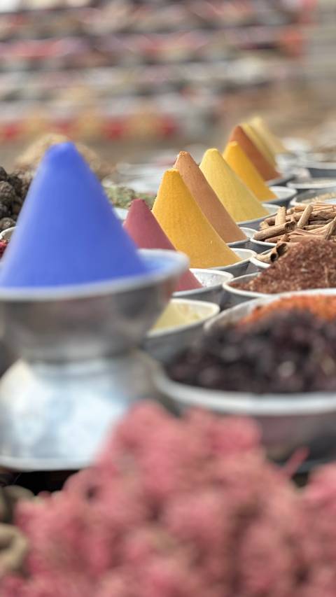      Colorful cones of spices displayed in metal bowls with soft focus artistic effect
  