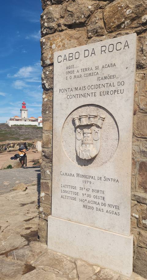       Stone crest reading 'Camara Municipal de Sintra' with a coastal lighthouse and guitarist in the background.
  