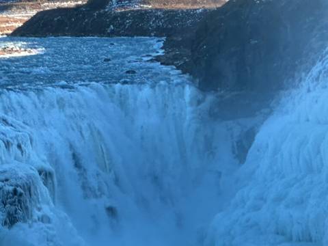       Close-up view of powerful icy waterfall plunging into a misty gorge
  