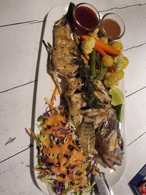       Plated grilled fish served with mixed vegetables, sauce and lime wedge
  
