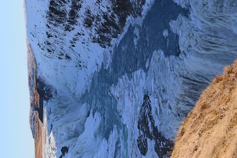       Wide icy gorge with a powerful river flowing through the frozen cliffs of Gullfoss waterfall.
  