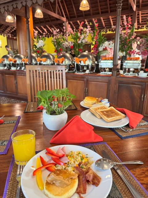       Breakfast table with toast, pancakes, bacon and orange juice in a wooden dining room.
  