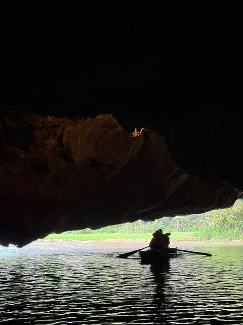      Dark cave interior with only faint natural light illuminating part of the rock ceiling.
  