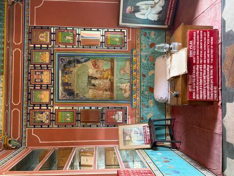       Colorful royal display room with detailed paintings and historical information panels.
  