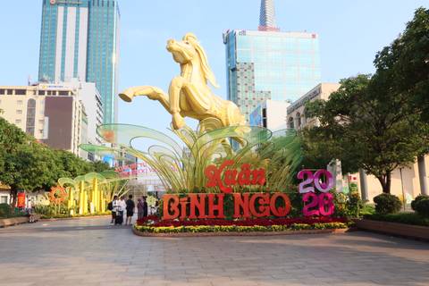       Colorful Tet holiday display with golden horse statue and bold floral signage on a pedestrian street in Ho Chi Minh City.
  