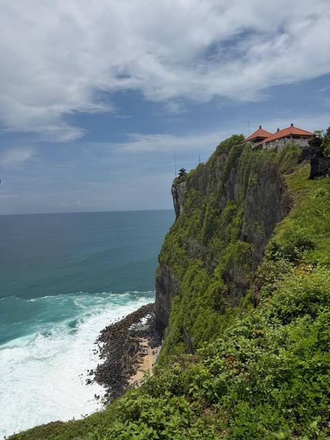       Dramatic ocean cliff with Uluwatu Temple perched on top in Bali.
  