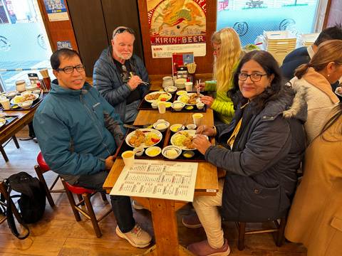       Travelers enjoying Japanese set meals at a casual restaurant table.
  