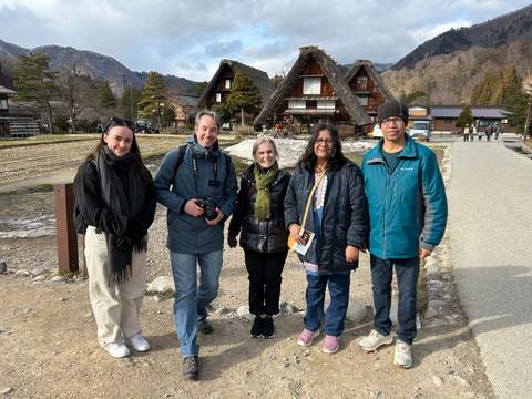       Group photo in front of traditional thatched houses in the mountain village of Shirakawa-go.
  