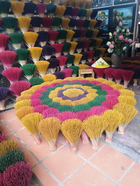       Colorful bundles of incense sticks arranged in concentric flower-like patterns
  