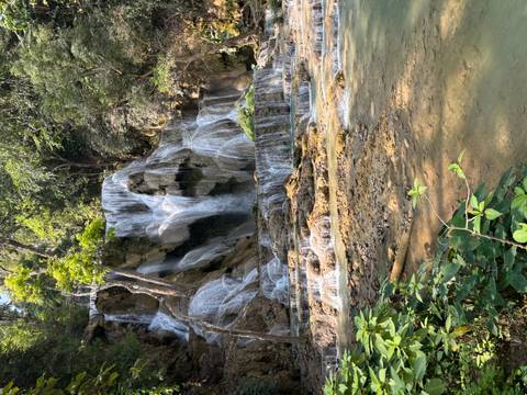       Tiered turquoise pools and cascades of Kuang Si Waterfall surrounded by jungle.
  