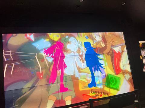      Colorful animated scene displayed on a large interior video screen.
  