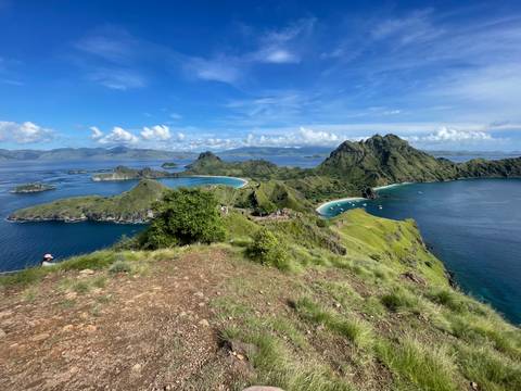       Sweeping vista from Padar Island with multiple crescent beaches and emerald sea framed by rugged peaks.
  