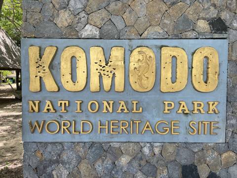       Stone monument bearing gold letters reading 'Komodo National Park World Heritage Site'.
  