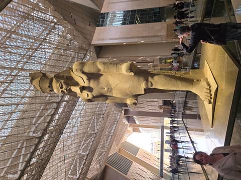       Giant standing statue of Ramses II inside the soaring glass atrium of the Grand Egyptian Museum
  