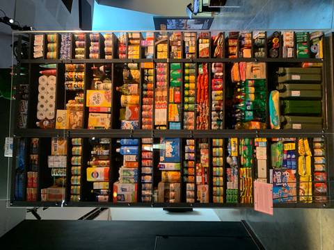       Tall shelves packed with colorful packaged groceries and household supplies in an indoor display.
  