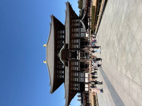       Large crowd gathers in front of Todai-ji’s sweeping wooden hall beneath a clear blue sky.
  