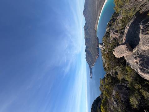       Panoramic view over Tasmania's curved Wineglass Bay and forested peninsula from lookout
  