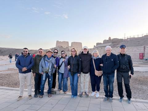       Same tour group smiles together in front of historic Egyptian ruins at Kom Ombo
  