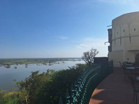       River view from fort terrace with outdoor seating looking over flooded plains under blue sky
  