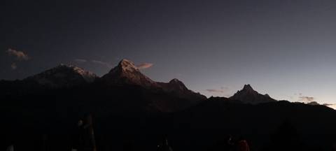       Pre-dawn Himalayan skyline captured in low light with faint pink clouds.
  