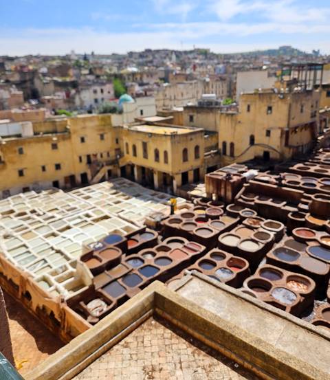       Blurry view over traditional dye vats of Fes tannery.
  