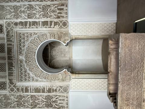       Detailed carved stone arch and columns of an ornate Moroccan interior.
  