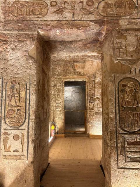      Interior walls of an ancient Egyptian tomb covered with detailed hieroglyphs and reliefs.
  