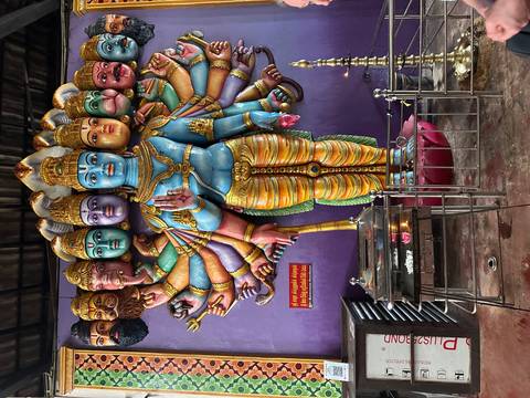       Vibrant multi-armed Hindu deity statue with vivid colors inside a Sri Lankan temple.
  