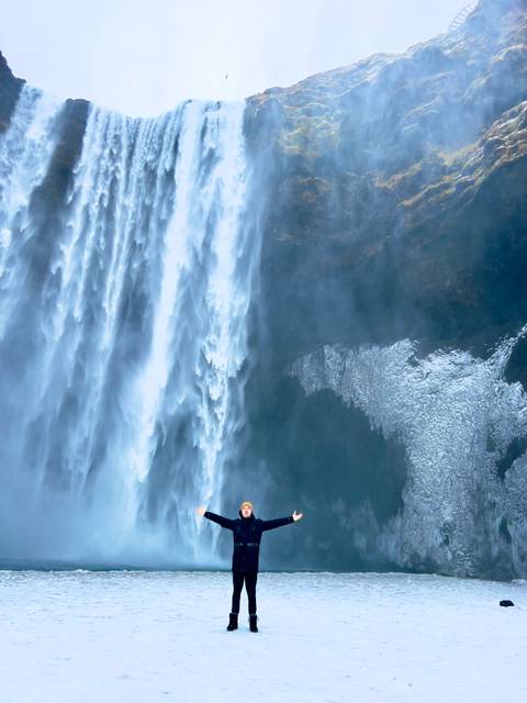       Abstract close-up of roaring waterfall spray alongside partially frozen rock face
  