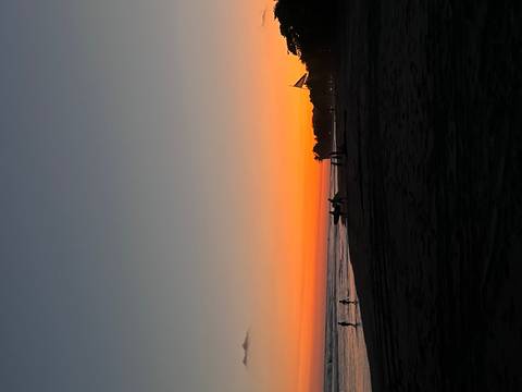       Silhouettes of people strolling along a tranquil Pacific beach at vivid orange sunset in Costa Rica.
  