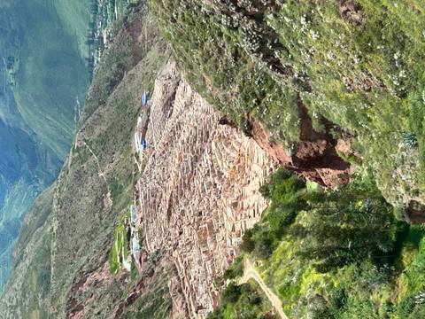       Aerial view of terraced salt pans cascading down a steep Andean valley at Maras.
  