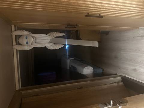       Dimly lit hotel cabin with a towel animal hanging playfully from the doorway
  