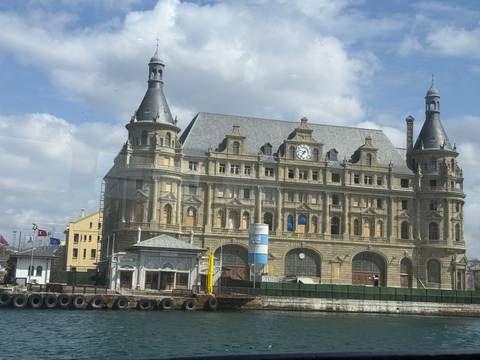       Historic Haydarpaşa railway station on Istanbul waterfront photographed through glass on a cloudy day
  