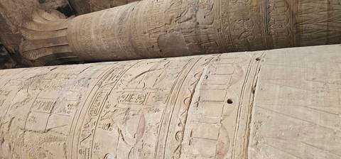       Close-up view of carved stone columns covered in detailed hieroglyphs
  