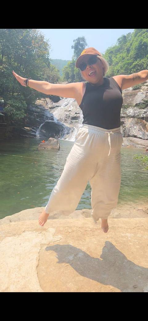      Partial view of a person standing at a riverside pool; composition is cropped and soft.
  