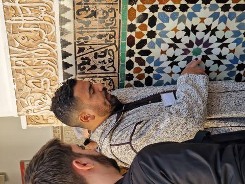       Local guide pointing out colorful zellige tile patterns and Arabic calligraphy
  
