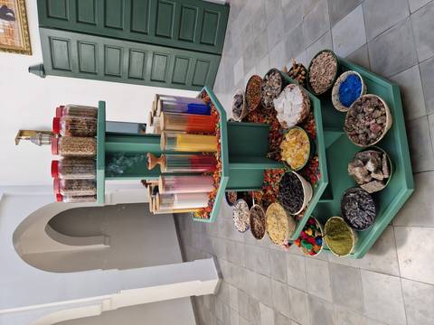      Colorful display of spices, minerals and pigments arranged in bowls around a tiered stand
  