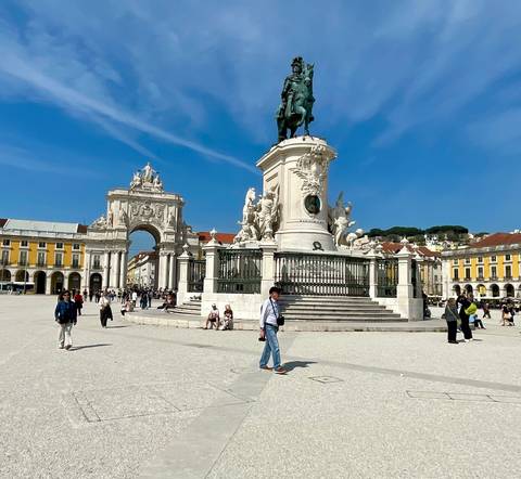       Praça do Comércio in Lisbon with the equestrian statue, Arco da Rua Augusta and visitors enjoying the sunny square.
  