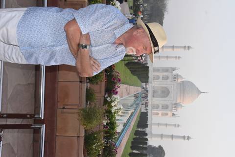      Traveller standing by the reflecting pool with the Taj Mahal rising majestically behind.
  