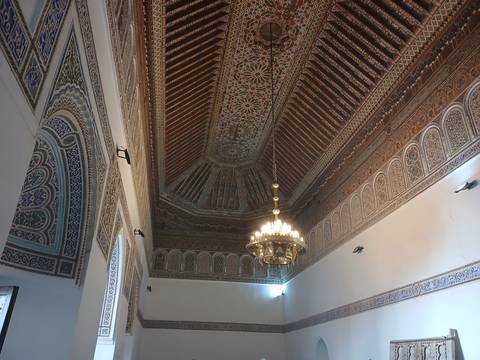       Highly detailed carved wooden ceiling and chandelier inside Moroccan palace
  