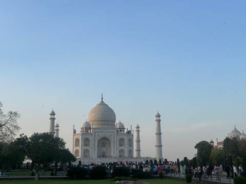       The iconic white marble Taj Mahal framed against a pale blue evening sky.
  