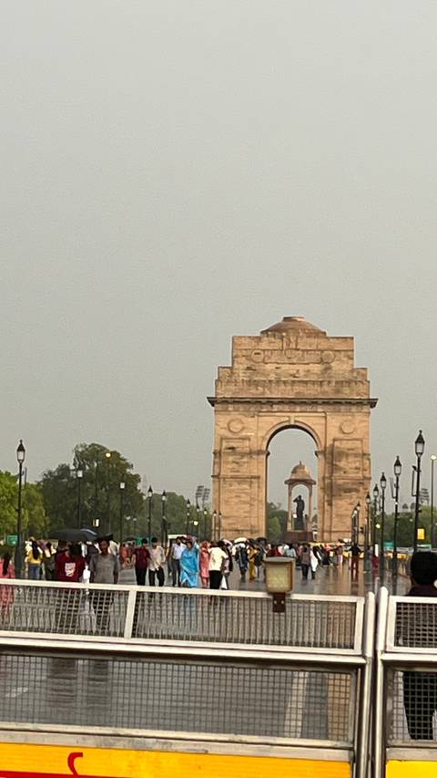       Close-up view of India Gate monument framed against a pale evening sky.
  