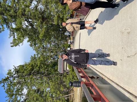       Visitors walking along a tree-lined footbridge in a Japanese park.
  