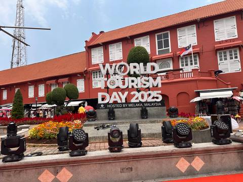       World Tourism Day 2025 display in front of the historic red Stadthuys building in Melaka.
  