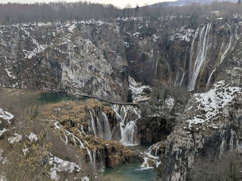       Snow-dusted waterfalls cascade through dramatic cliffs and lakes in Plitvice Lakes Park.
  