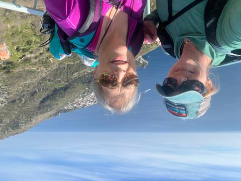       Selfie of two women with backpacks overlooking the Amalfi Coast and deep blue sea.
  