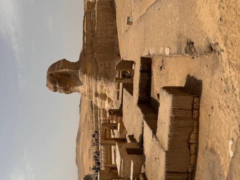       Great Sphinx of Giza profile with desert plateau and tourists in distance
  