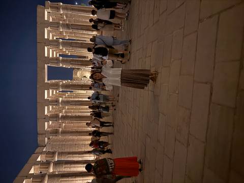       Evening scene at illuminated columned hall of Luxor Temple with visitors
  