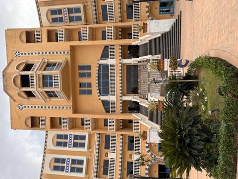       Grand multi-storey hotel entrance with tall staircase and balconies in a Mediterranean style
  